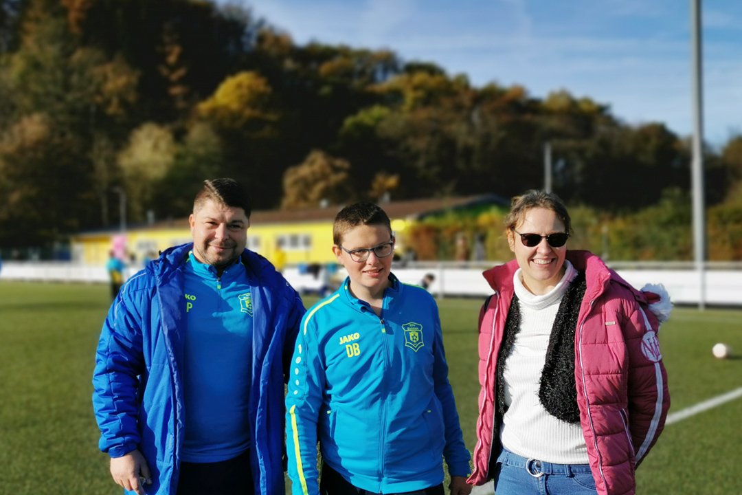 Samstags auf dem Fußballplatz in Bielstein. Mit Hilfe von Serv In hat Daniel ein neues Hobby gefunden (von links: Christopher Pethe, COO des BSV Viktoria Bielstein, Daniel Beer und seine Mutter Ramona Beer)