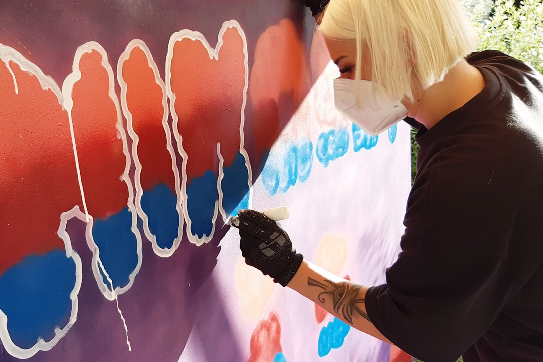 Diese junge Frau bringt gerade auf die Leinwand, was ihr in Corona-Zeiten geholfen hat. Graffiti-Projekt unserer Offenen Jugendberufshilfe Leverkusen.